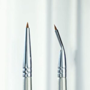 Fine angled eyeliner brush with silver handle and synthetic bristles, designed for gel eyeliner, detailed eye makeup, lash line definition, and precision cosmetic application.