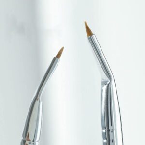 Professional fine-tip eyeliner and eyebrow brush with silver handle and synthetic bristles, designed for detailed eye makeup, brow shaping, and cosmetic precision work.