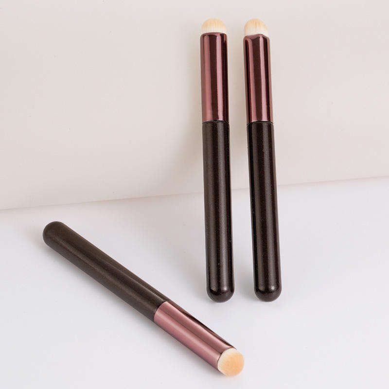 Compact multifunctional flat makeup brush with synthetic bristles and metallic handle, suitable for lipstick, lip gloss, concealer, and detailed facial makeup application.