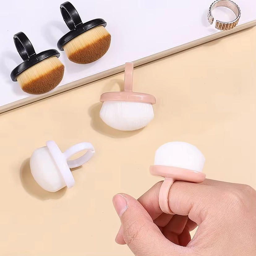 Compact round nail cleaning brush with soft synthetic bristles and black handle designed for removing nail art dust, powder, and manicure residue.