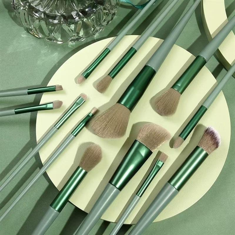 Professional green makeup brush set with storage pouch, featuring synthetic powder brushes, angular flat contour brushes, blending brushes, and precision eye makeup tools for flawless cosmetic application.