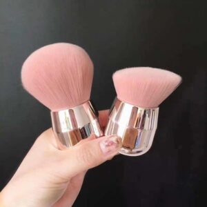 Compact fluffy makeup brush with ultra-soft pink synthetic bristles and a metallic handle, suitable for blush, bronzer, nail powder application, and manicure dust removal.