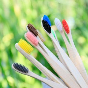 Pack of ten eco-friendly bamboo toothbrushes with colorful BPA-free bristles and recyclable kraft paper packaging, designed for adults and sustainable oral care